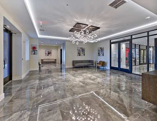 a large lobby with glass doors and a chandelier