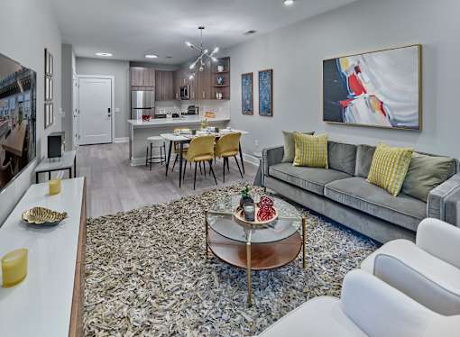 a living room and kitchen with a couch and a table