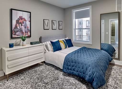 a bedroom with a bed and a dresser with a mirror