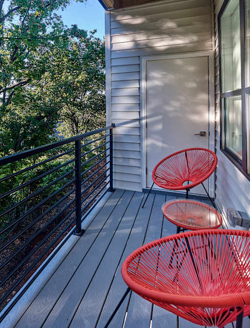 a balcony with two chairs and a table and a door