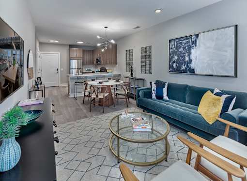 a living room and kitchen with a blue couch and a table