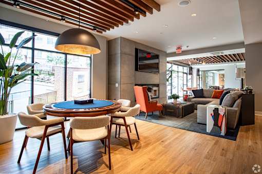 Game table lounge with pendant lighting and seating at Inwood at Renaissance Square Apartments, Marlton
