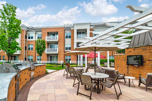 Outdoor patio with grilling stations and dining pergola at Highlands at Hilltop Apartments, Verona