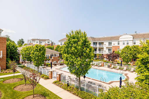 Pool deck with lounge seating and surrounding greenery at Highlands at Hilltop Apartments, Verona, NJ 07044