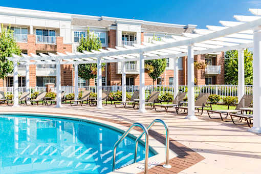 Swimming pool with white pergola and lounge seating at Highlands at Hilltop Apartments, Verona, New Jersey