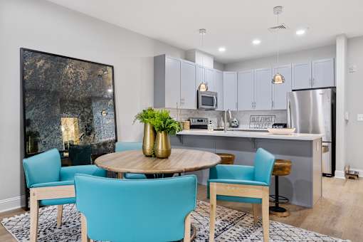 Open dining area with kitchen island and turquoise seating at Highlands at Hilltop Apartments, Verona, NJ 07044