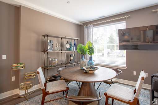 Dining room with round table and industrial shelving at Inwood at Renaissance Square Apartments, New Jersey