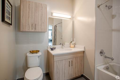 Bathroom with wood tone vanity and mirror cabinet at Inwood at Renaissance Square Apartments, Marlton, 08053