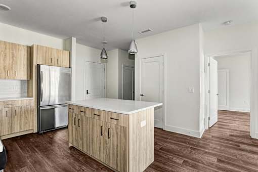 Open kitchen with wood cabinetry and white island at Inwood at Renaissance Square Apartments, Marlton, New Jersey