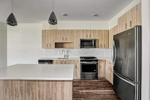 Modern kitchen with stainless steel appliances and wood cabinets at Inwood at Renaissance Square Apartments, Marlton, NJ 08053