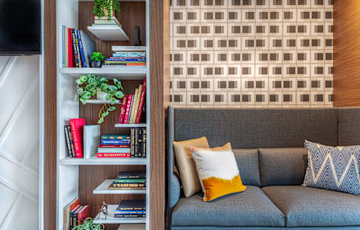 Builtin bookshelf with gray sofa and decorative pillows at Inwood at Renaissance Square Apartments, Marlton, NJ