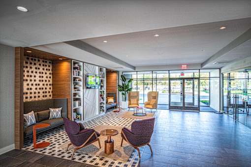 Lobby seating area with glass entrance doors at Inwood at Renaissance Square Apartments, Marlton, 08053