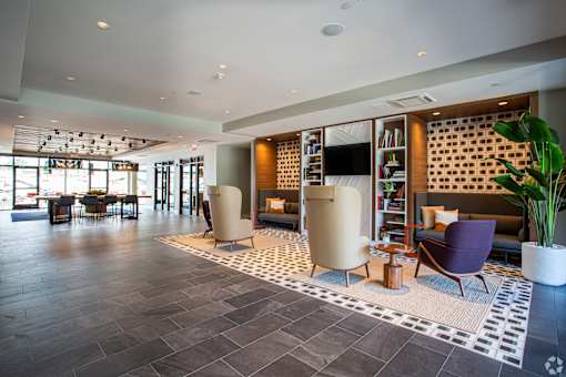 Modern lobby lounge with shelving and comfortable seating at Inwood at Renaissance Square Apartments, Marlton, New Jersey