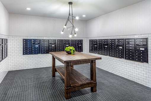 Mail room with lockable mailboxes and center table at Inwood at Renaissance Square Apartments, New Jersey