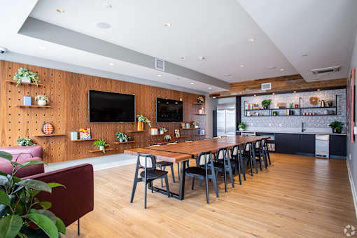 Communal dining space with long wood table and pegboard wall at Inwood at Renaissance Square Apartments, Marlton, NJ