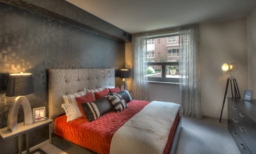 Modern bedroom with colorful bedding and natural light at RiverParc Apartments, Weehawken, 07086