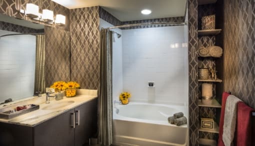 Modern bathroom with white tub and vanity at RiverParc Apartments, Weehawken, New Jersey
