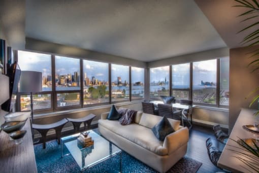 Living room with panoramic city skyline views at RiverParc Apartments, New Jersey, 07086
