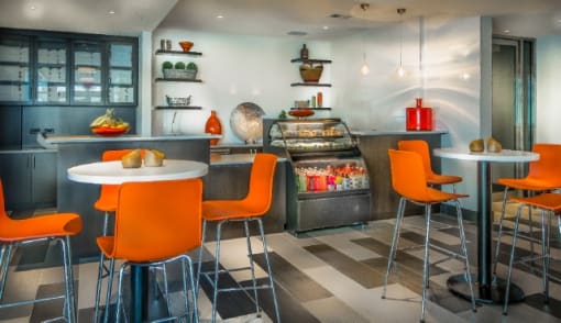 Cafe with orange seating and display case at RiverParc Apartments, Weehawken, 07086