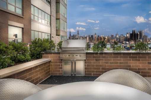 Rooftop grilling area with built in barbecue and city skyline views at RiverParc Apartments, Weehawken, 07086