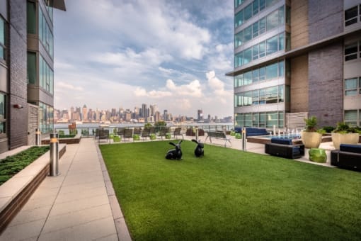 Rooftop terrace with lawn and city skyline views at RiverParc Apartments, Weehawken, New Jersey