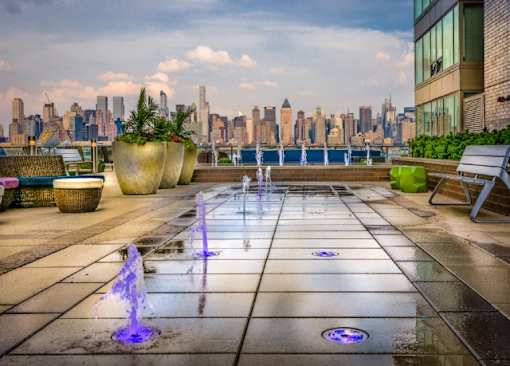 Rooftop terrace with water fountains and manhattan skyline views at RiverParc Apartments, New Jersey