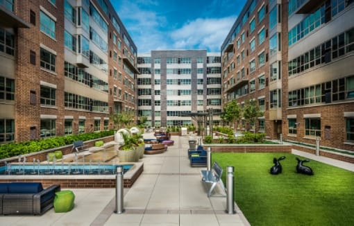 Courtyard with green lawn and surrounding buildings at RiverParc Apartments, Weehawken, NJ 07086