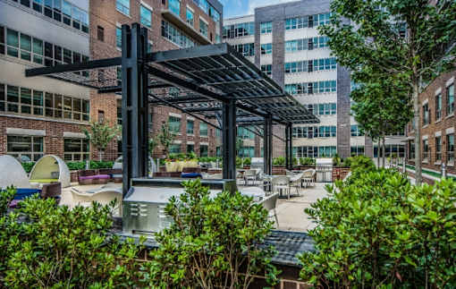 Outdoor courtyard with modern pergola and dining area at RiverParc Apartments, Weehawken