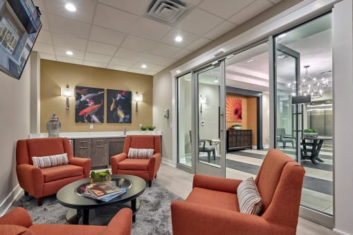 a living room with orange chairs and a table