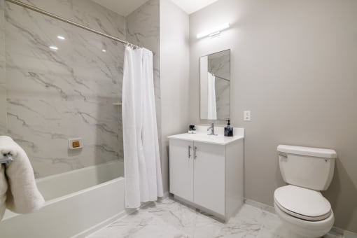 a bathroom with a white sink and toilet next to a bathtub with a shower curtain