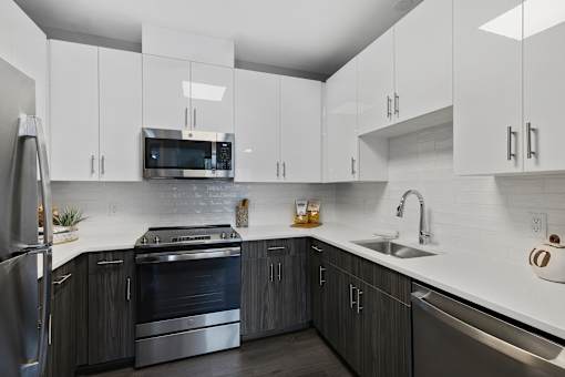 A modern kitchen with dark wood cabinets and stainless steel appliances.