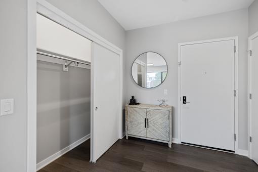 A bathroom with a round mirror and a white cabinet.