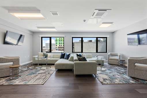 A living room with a large couch and a rug.
