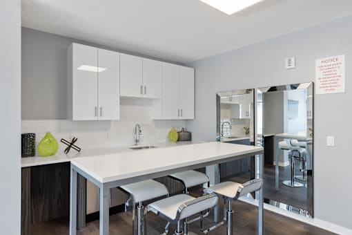 A modern kitchen with a white countertop and grey cabinets.