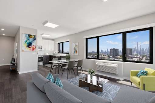 A modern living room with a grey sofa and a view of the city.