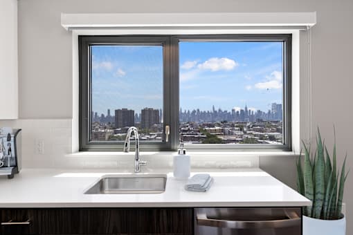 A modern kitchen with a large window overlooking a cityscape.