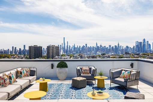 A rooftop patio with a city skyline in the background.