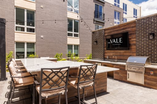 the outdoor patio of a condo with a bar and a grill