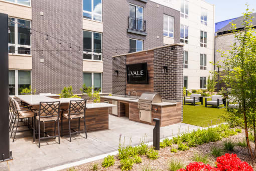 an outdoor patio with a grill and a table with chairs