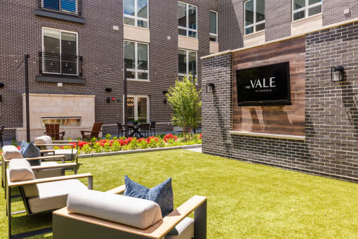 the apartments have a large yard with furniture and a fireplace