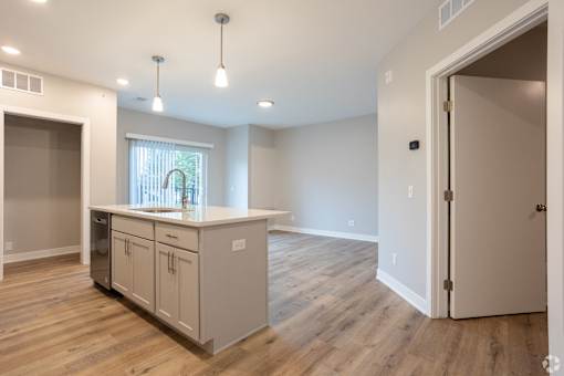 A kitchen with a window and wooden floors.