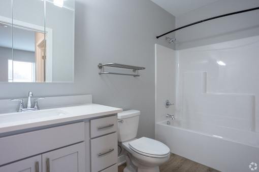 A white toilet sits next to a sink in a modern bathroom.