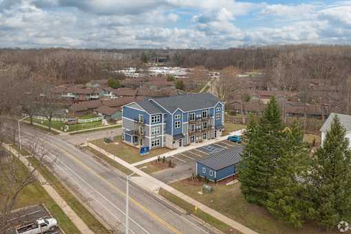 A blue building is in the middle of a road.
