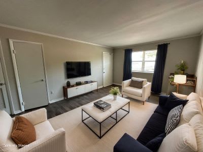 Spacious living room with natural light in classic unrenovated 1- and 2-bedroom apartments at Lynnhaven Landing in Virginia Beach