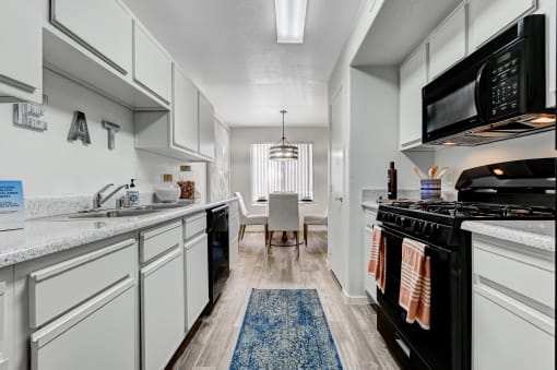 a kitchen with cabinets and black appliances at The Dresden, Nevada, 89122