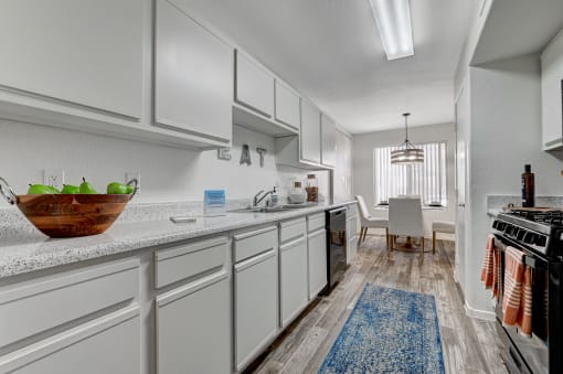 Kitchen with white cabinets and black appliances at The Dresden, Nevada