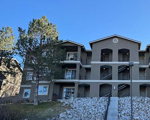 A large apartment building with a tree in front of it.