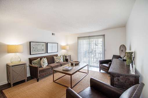 A living room with a brown couch, a coffee table, and a lamp.