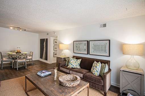 A living room with a brown couch and a coffee table.