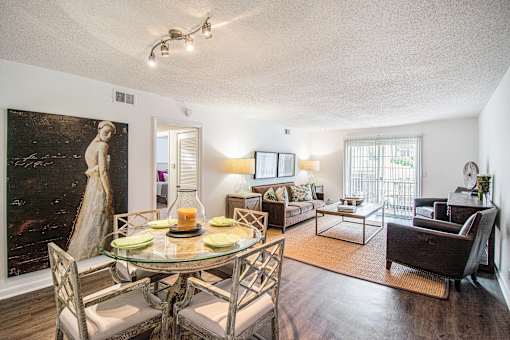 A living room with a glass table and chairs.